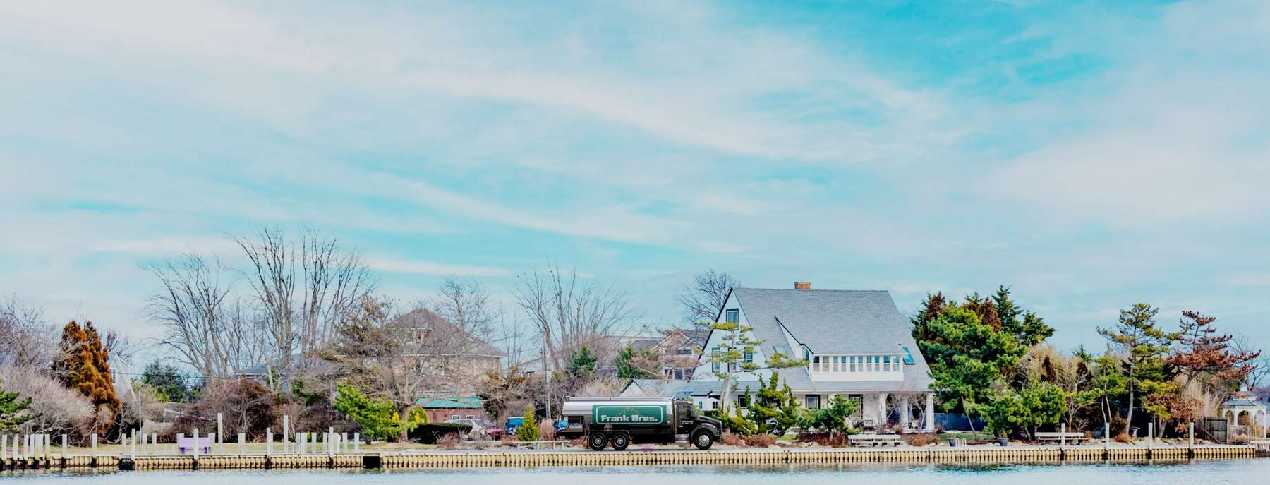 Fuelco Heating Oil Truck Fuelco residential home heating oil truck next to a large white home with a large American Flag hanging on the side in Wantagh, Long Island, New York delivering fuel oil.