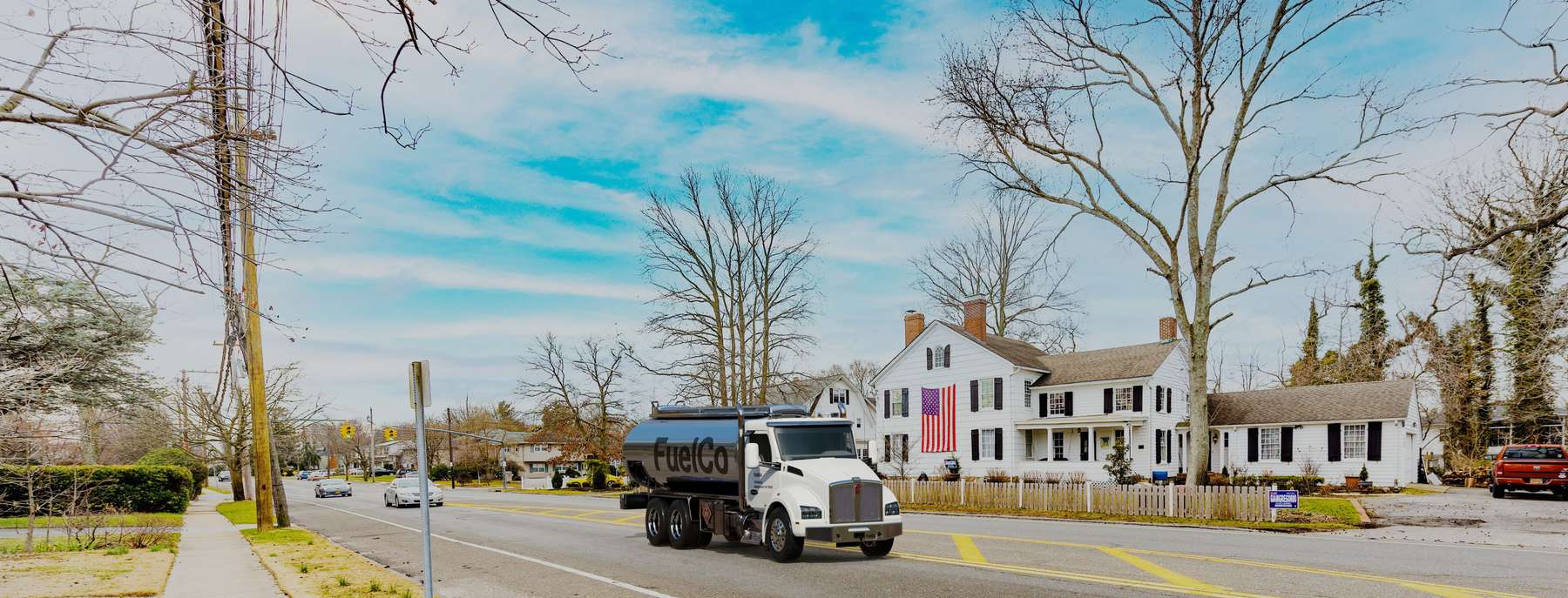 Fuelco Heating Oil Truck Fuelco residential home heating oil truck next to a large white home with a large American Flag hanging on the side in Wantagh, Long Island, New York delivering fuel oil.