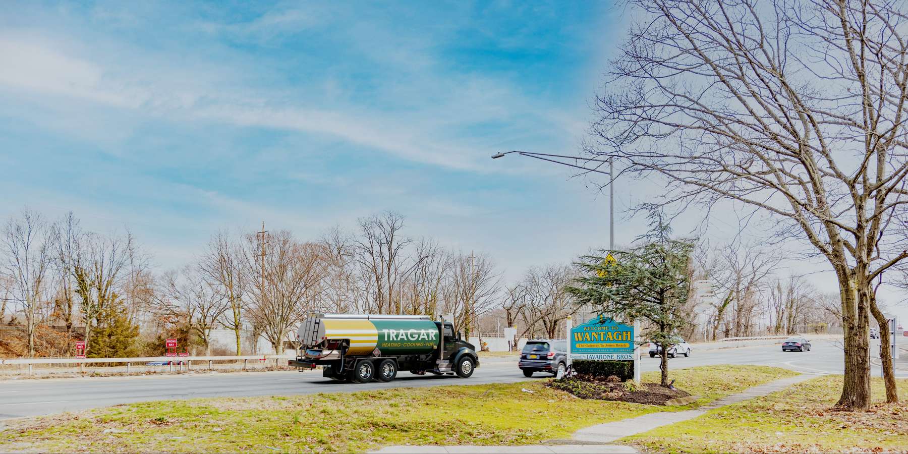 Residential heating oil truck with the Gateway To Jones Beach sign in Wantagh, Long Island, New York delivering fuel oil. Residential heating oil truck with the Gateway To Jones Beach sign in Wantagh, Long Island, New York delivering fuel oil.