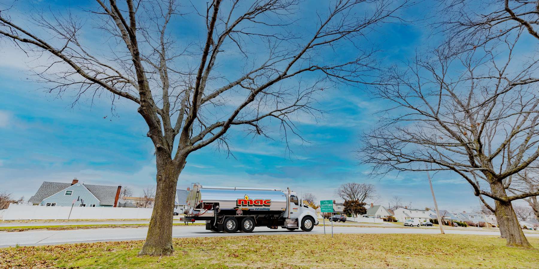 Residential heating oil truck with the Welcome To Levittown sign in Levittown, Long Island, New York delivering fuel oil. Residential heating oil truck with the Welcome To Levittown sign in Levittown, Long Island, New York delivering fuel oil.