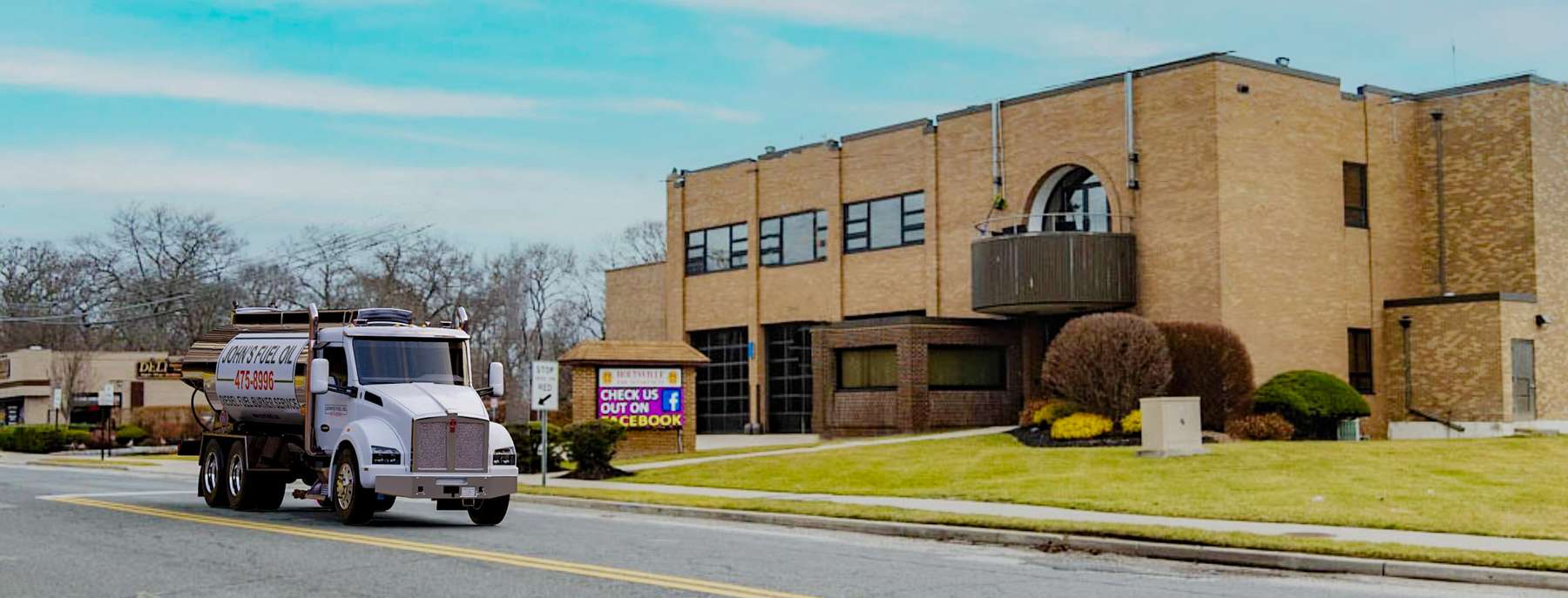 John's Fuel Heating Oil Truck  John's Fuel residential home heating oil truck on a road adjacent to a brick building in Holtsville, Long Island, New York delivering fuel oil.