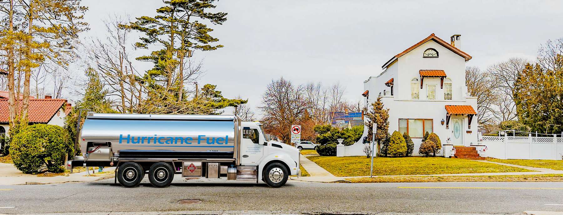 Hurricane Fuel Heating Oil Truck Hurricane Fuel residential home heating oil truck with a stucco house with a ceramic tile roof in Baldwin, Long Island, New York delivering fuel oil.