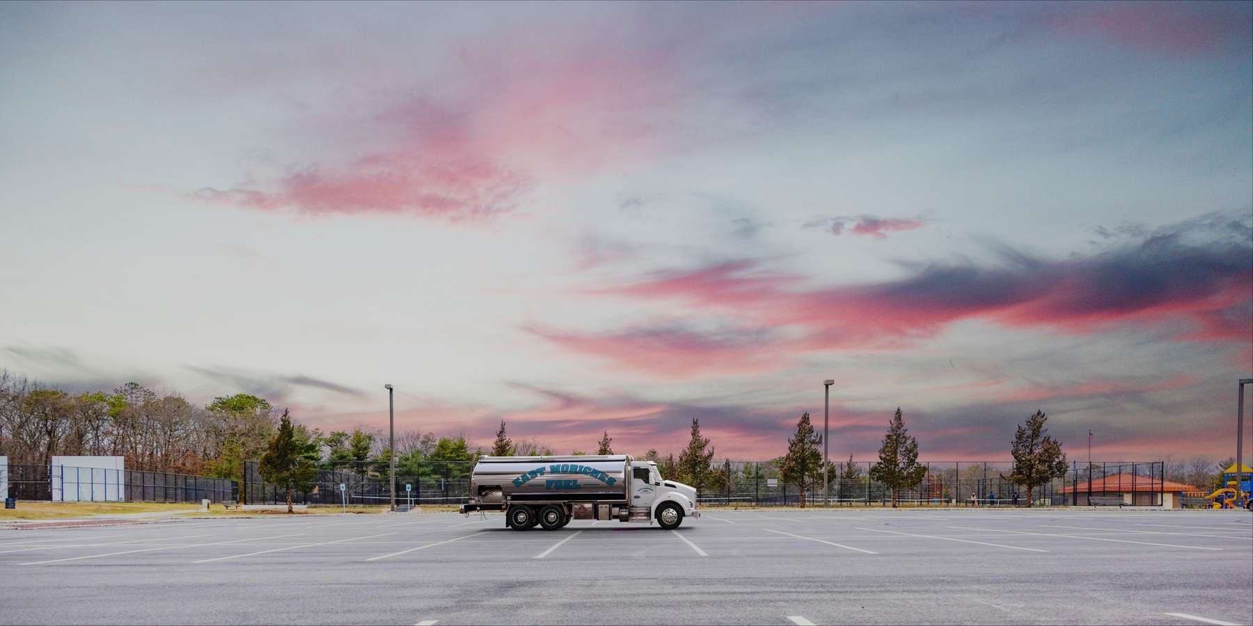 Residential heating oil truck in a parking lot at sunset in East Setauket, Long Island, New York delivering fuel oil. Residential heating oil truck in a parking lot at sunset in East Setauket, Long Island, New York delivering fuel oil.