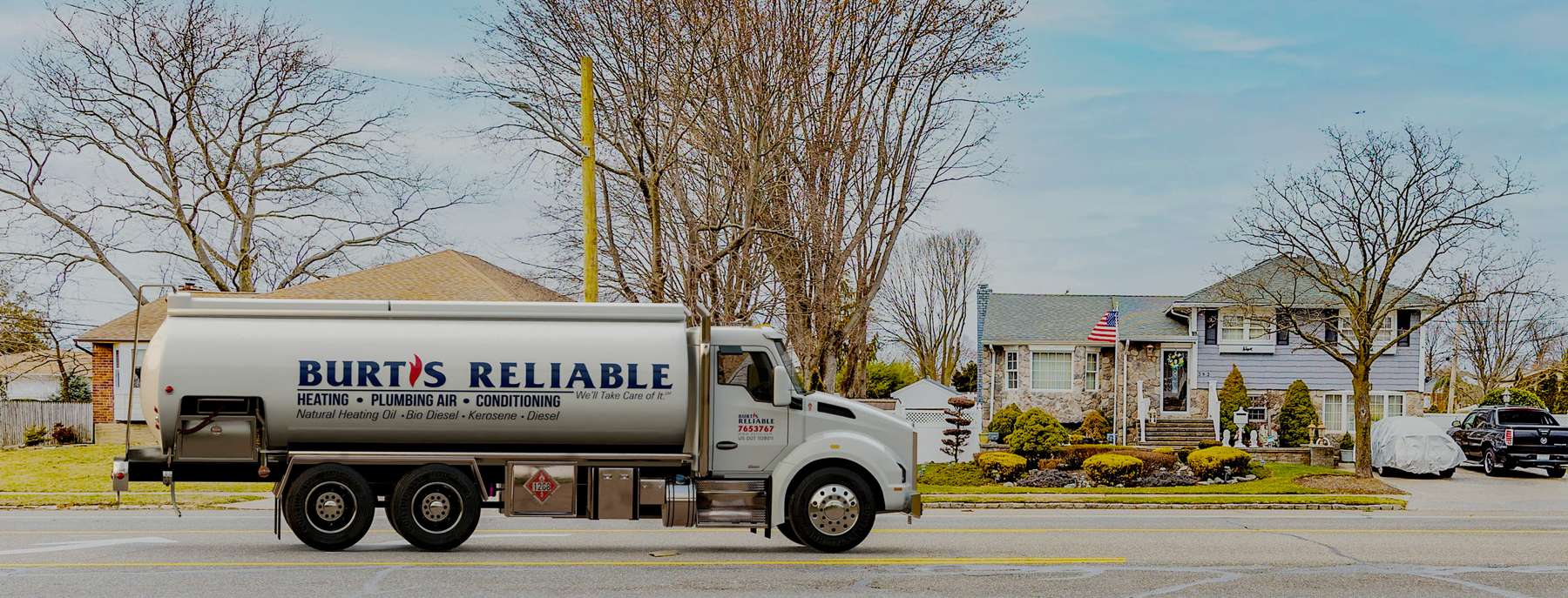 Burt's Reliable Heating Oil Truck Burt's Reliable residential home heating oil truck with a gray shingle and stone house flying an American flag in Wyandanch, Long Island, New York delivering fuel oil.